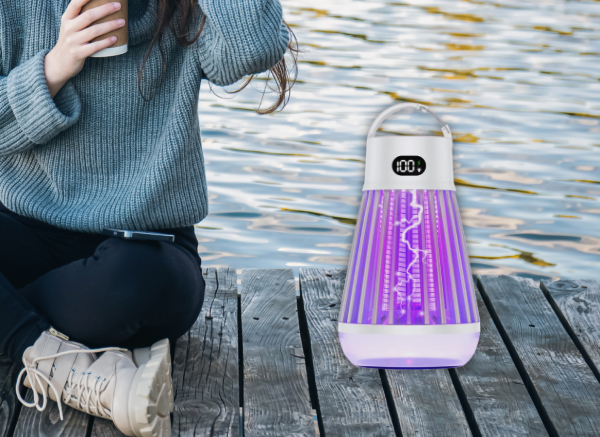 ZapShield zapper placed on a lakeside dock beside a seated woman at dusk